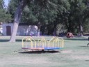 Merry Go Round and outdoor exercise equipment in the back at South Park (Pioneer)